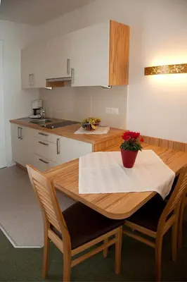 a kitchen with a wooden table and a table and chairs at Living Apartments Morgenstern in Merano