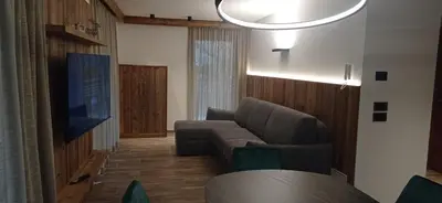 a living room with a couch and a tv at Chalet Radola in Campitello di Fassa