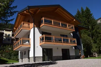 a building with wooden balconies on top of it at Chalet Radola in Campitello di Fassa