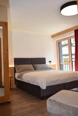 a large bed in a room with a window at Chalet Radola in Campitello di Fassa