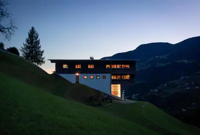 a house on a hill with the lights on at LA FUNDNEYT art & guesthouse in Laion