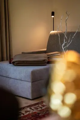 a living room with a couch with a book on it at LA FUNDNEYT art & guesthouse in Laion