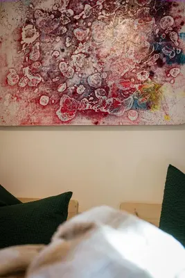 a painting hanging on a wall next to a couch at LA FUNDNEYT art & guesthouse in Laion