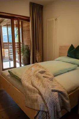 a bed with a blanket on it in a bedroom at LA FUNDNEYT art & guesthouse in Laion