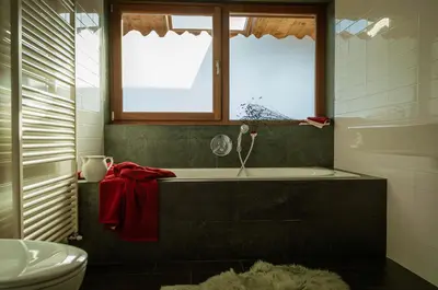 a bathroom with a tub and a window and a toilet at LA FUNDNEYT art & guesthouse in Laion