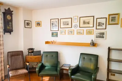 a waiting room with two chairs and a clock at Casa Tullia by Go New Location in Ziano di Fiemme