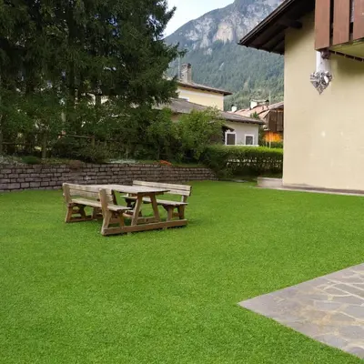 a picnic table and bench on a lawn at Casa Tullia by Go New Location in Ziano di Fiemme