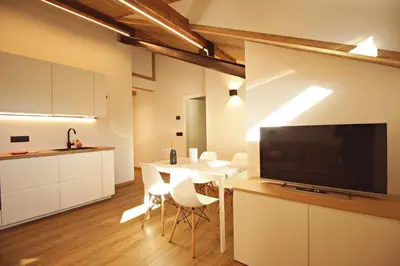 a kitchen and dining room with a table and a television at Guest House Dezulian in Castello di Fiemme