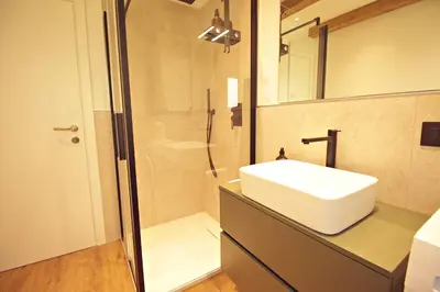 a bathroom with a sink and a shower at Guest House Dezulian in Castello di Fiemme