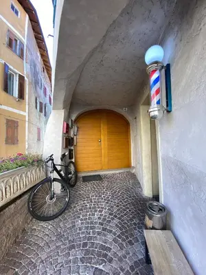 a bike parked next to a building with a wooden door at Ciasablè in Fondo