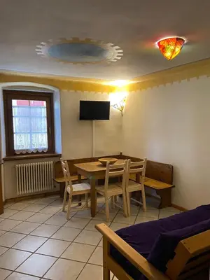 a dining room with a table and chairs and a tv at Ciasablè in Fondo