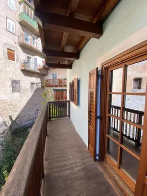 a balcony with a wooden walkway next to a building at Ciasablè in Fondo