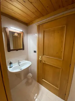a bathroom with a sink and a wooden door at Ciasablè in Fondo