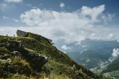 a grassy hill with people standing on top of it at La Maison 35 - Bruneck - zentral gelegene Appartments in Brunico