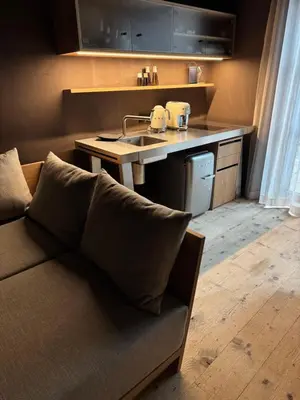 a living room with a couch and a kitchen with a sink at La Maison 35 - Bruneck - zentral gelegene Appartments in Brunico