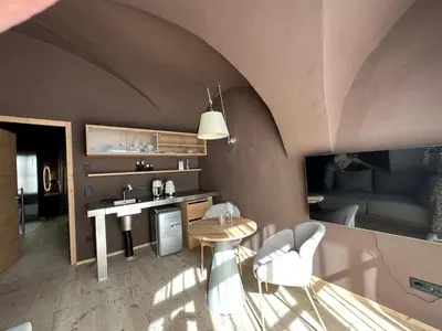 a living room with a table and chairs and a couch at La Maison 35 - Bruneck - zentral gelegene Appartments in Brunico