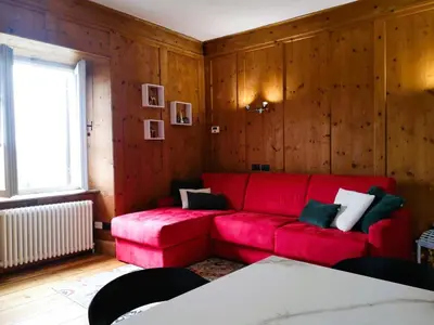 a red couch in a room with wooden walls at Casa Angelica by Sunhome Fiemme in Varena