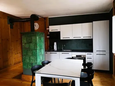 a kitchen with a white table and a fireplace at Casa Angelica by Sunhome Fiemme in Varena