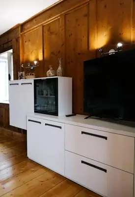 a living room with white cabinets and a flat screen tv at Casa Angelica by Sunhome Fiemme in Varena