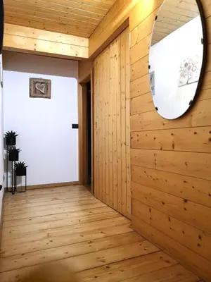 a hallway with wood paneling and a round mirror at Casa Angelica by Sunhome Fiemme in Varena