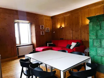 a living room with a red couch and a table at Casa Angelica by Sunhome Fiemme in Varena