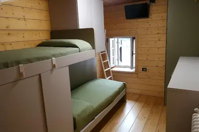 two bunk beds in a room with a window at Casa Angelica by Sunhome Fiemme in Varena