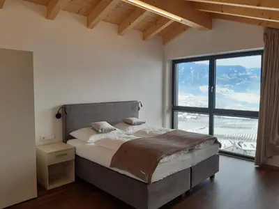a bedroom with a large bed with a large window at Appartements Laimer in Haslach in Tirolo