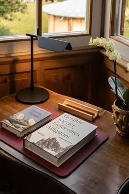 two books sitting on top of a wooden table at Berghoferin Fine Hotel & Hideaway in Redagno
