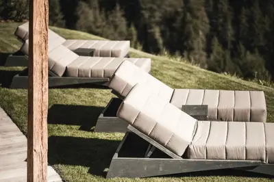 a row of benches sitting on the grass at Chalet Altera by Elite Villas in Ortisei