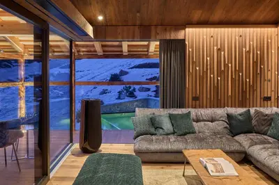 a living room with a couch and a large window at Chalet Altera by Elite Villas in Ortisei