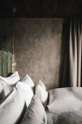 a bed with white pillows on top of it at Chalet Altera by Elite Villas in Ortisei