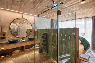 a bathroom with a shower and a sink and a mirror at Chalet Altera by Elite Villas in Ortisei
