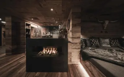 a living room with a fireplace and a couch at Chalet Altera by Elite Villas in Ortisei