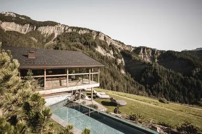 a house with a pool in front of a mountain at Chalet Altera by Elite Villas in Ortisei