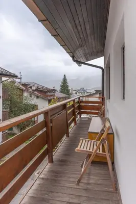 a wooden balcony with a bench on the side of a building at Casa De Zeto, con balcone e vicina al centro in Cortina dʼAmpezzo