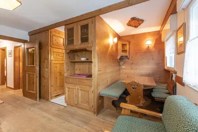 a room with a table and chairs in a tiny house at Casa De Zeto, con balcone e vicina al centro in Cortina dʼAmpezzo