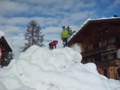 two people standing on top of a pile of snow at Chalet Frapes in San Martino in Badia