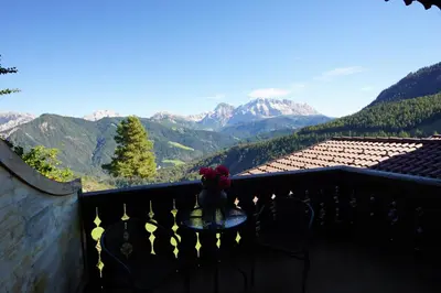 a table on a balcony with a view of mountains at Chalet Frapes in San Martino in Badia