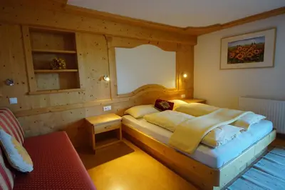 a bedroom with a bed in a wooden room at Chalet Frapes in San Martino in Badia