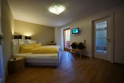a bedroom with a bed with yellow pillows and a window at Chalet Frapes in San Martino in Badia