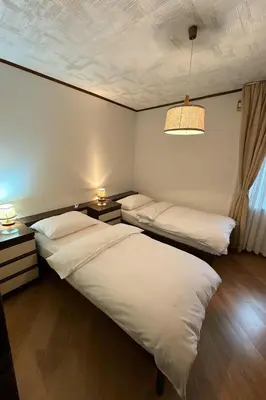 a bedroom with two beds and a chandelier at Casa Checolongo by Sunhome Fiemme in Ziano di Fiemme