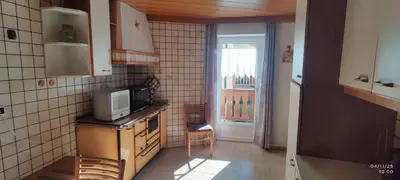 a kitchen with a microwave on a stove and a window at Casa Checolongo by Sunhome Fiemme in Ziano di Fiemme