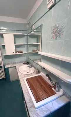 a bathroom with a sink with a wooden cutting board at Casa Checolongo by Sunhome Fiemme in Ziano di Fiemme