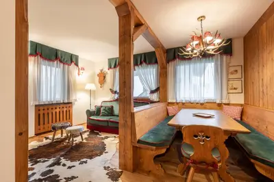 a bedroom with a bed and a table in a room at Appartamento 5 Torri - Dolce Vita Stay in Cortina dʼAmpezzo