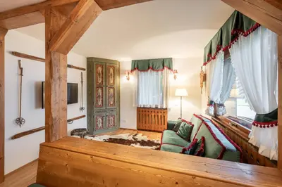 a living room with a couch and a tv at Appartamento 5 Torri - Dolce Vita Stay in Cortina dʼAmpezzo