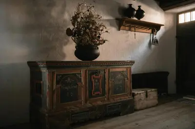 an old wooden cabinet with a vase on top of it at Historic Alpine Lodge In The Heart Of South Tyrol in Villandro
