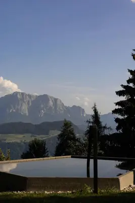 a swimming pool with mountains in the background at Historic Alpine Lodge In The Heart Of South Tyrol in Villandro