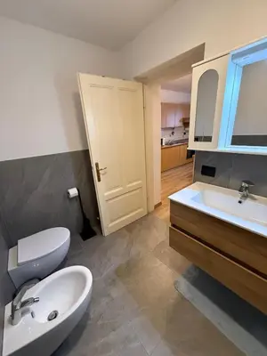 a bathroom with a white toilet and a sink at Appartamento Moena in Moena