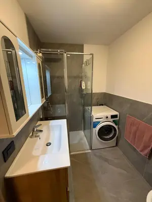 a bathroom with a sink and a washing machine at Appartamento Moena in Moena