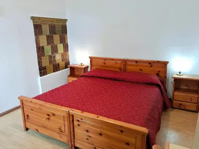 a bedroom with a wooden bed with a red bedspread at Casa Bruna by Go New Location in Varena